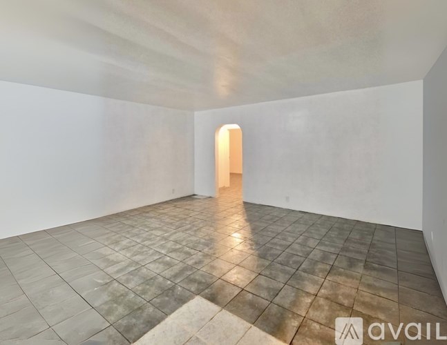A room with a tiled floor and a doorway leading to another room.
