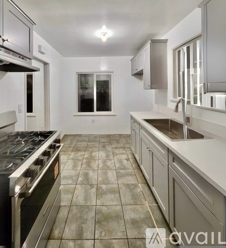A kitchen with a stove top oven and a sink.