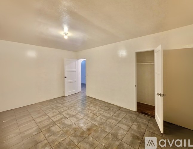A room with tiled flooring and two doors, one of which is open.