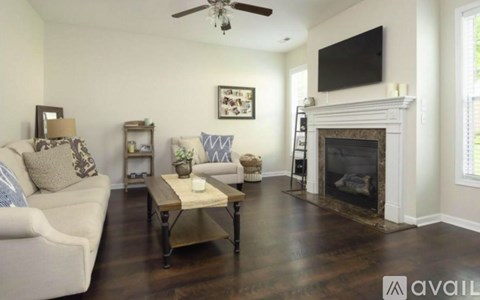 A living room with a fireplace and a television mounted above it.
