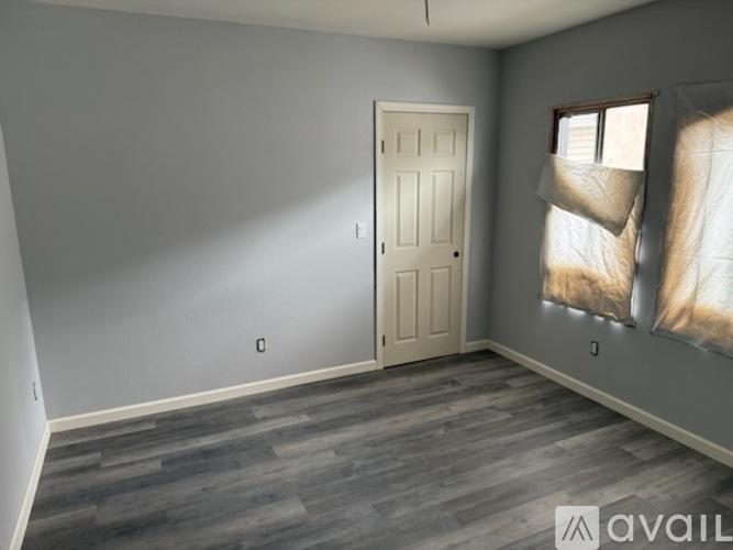 A room with a door and a window with curtains.