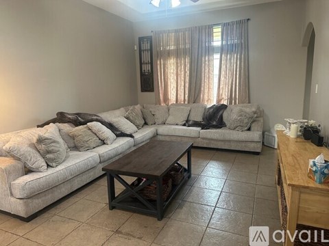 A living room with a grey sectional sofa and a wooden coffee table.