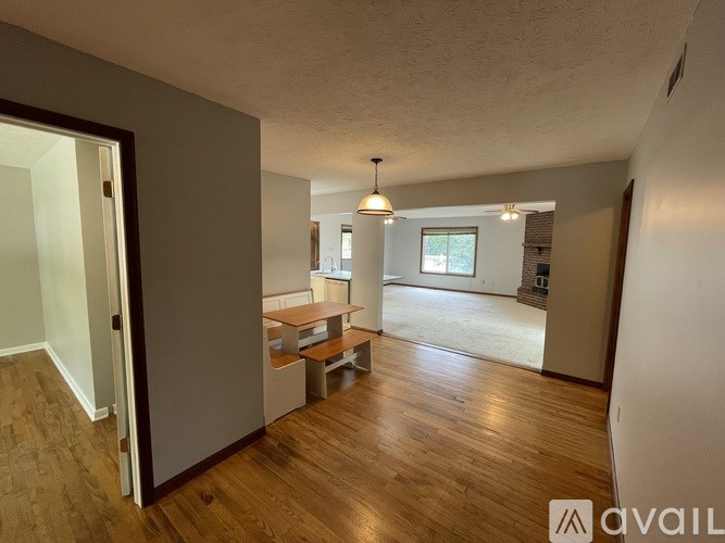 A room with wooden floors and a table with chairs.