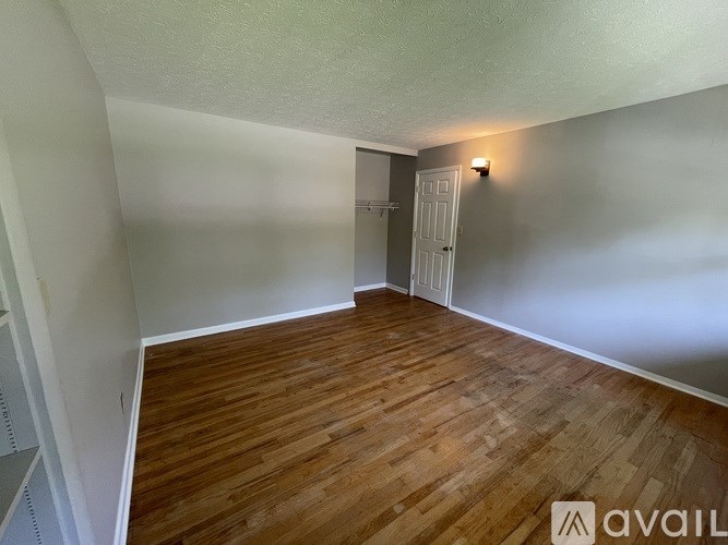 A room with wooden flooring and a white door.