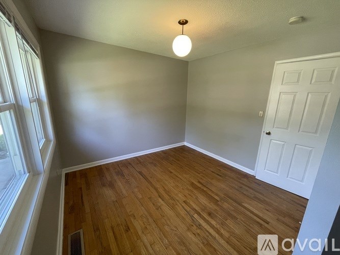 A room with wooden flooring and a white door.