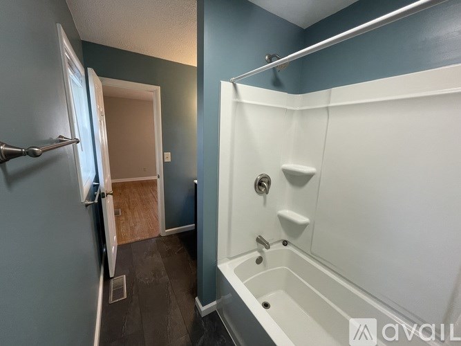 A white door is in a hallway next to a blue wall.