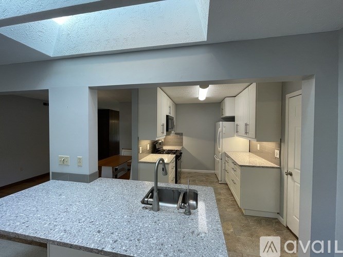 A basketball court is surrounded by a fence and a basketball hoop is visible.