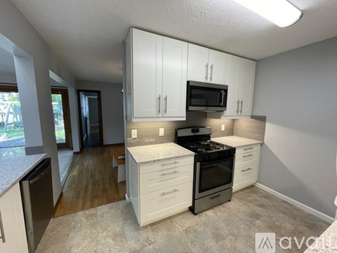 A kitchen with white cabinets and a black stove top oven.