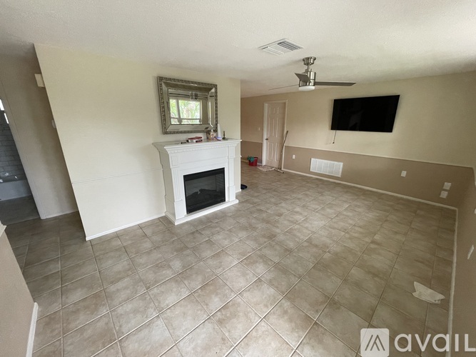A living room with a fireplace and a flat screen TV mounted on the wall.