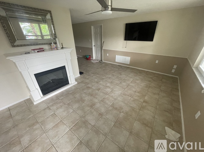 A living room with a fireplace and a flat screen TV mounted on the wall.