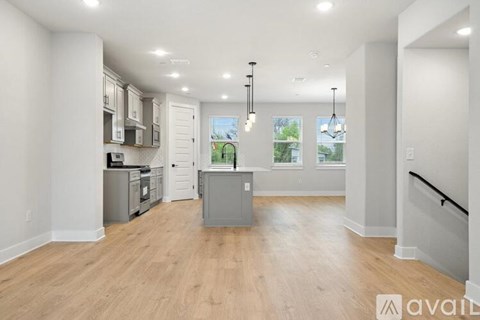 A spacious kitchen with wooden floors and modern appliances.