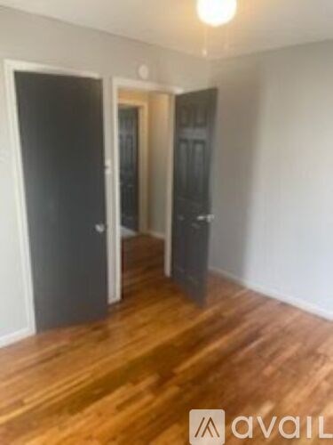 A room with wooden floors and two doors.