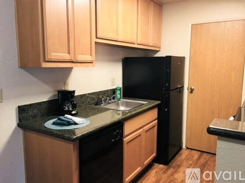 A kitchen with wooden cabinets and black appliances.
