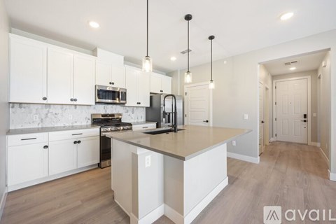 A modern kitchen with white cabinets and a central island.