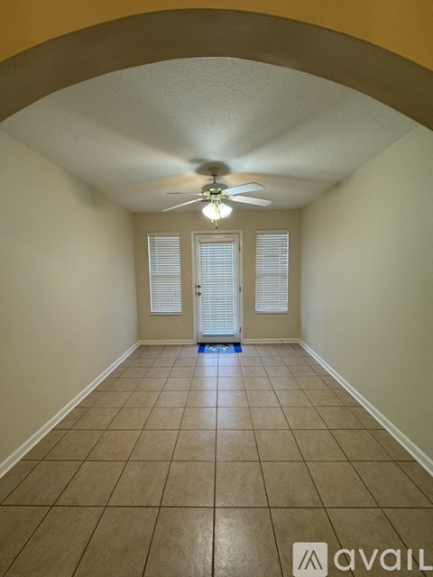 A room with a ceiling fan and tiled floor.