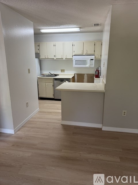 A kitchen area with a microwave, oven, and cabinets.
