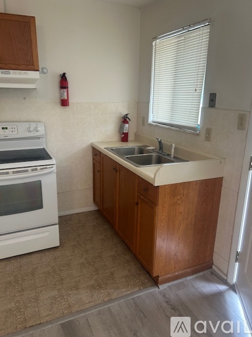 A kitchen with white appliances and wooden cabinets.