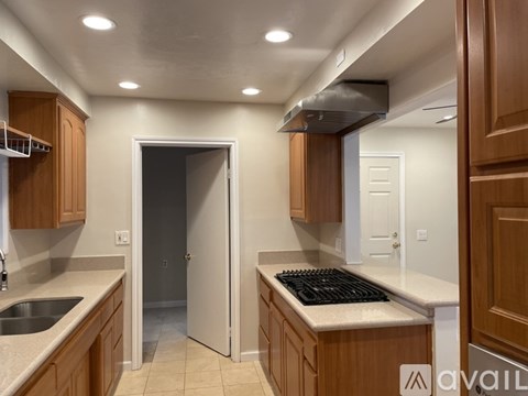 A kitchen with wooden cabinets and a black stove top.