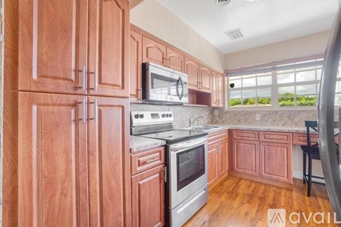 A kitchen with wooden cabinets and a stainless steel oven.