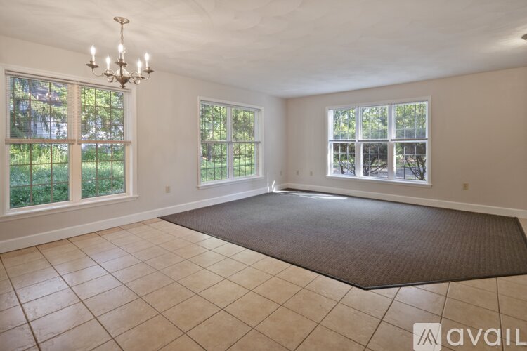 A large, empty room with a chandelier and large windows.