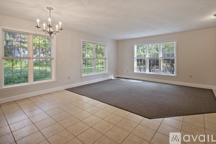 A large, empty room with a chandelier and large windows.