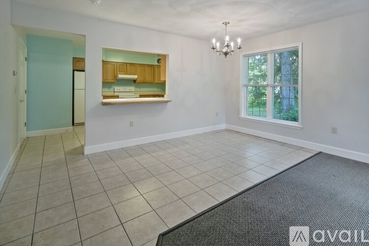 A room with a chandelier, a window, and a door.