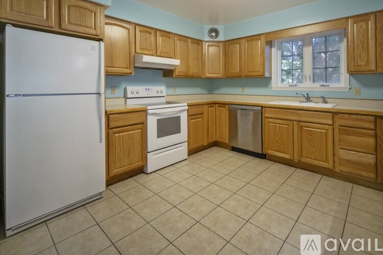 A kitchen with wooden cabinets and a white refrigerator.