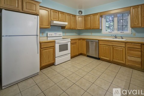 A kitchen with wooden cabinets and a white refrigerator.