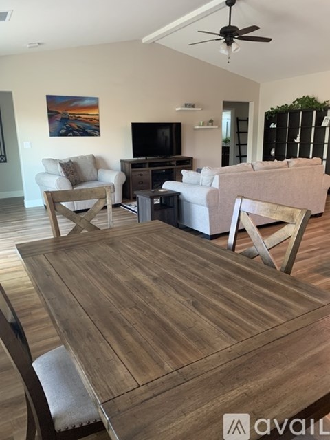 A living room with a wooden table and chairs.