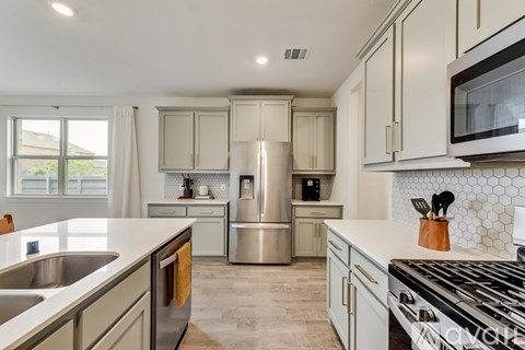 A kitchen with a stove top oven and a refrigerator.