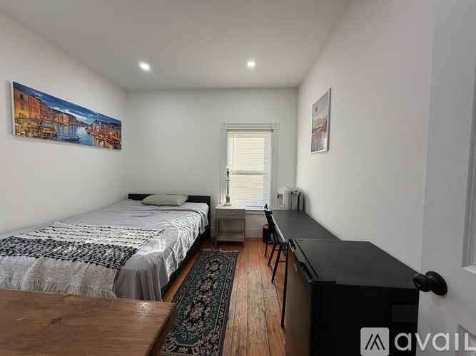A bedroom with two beds and a desk.
