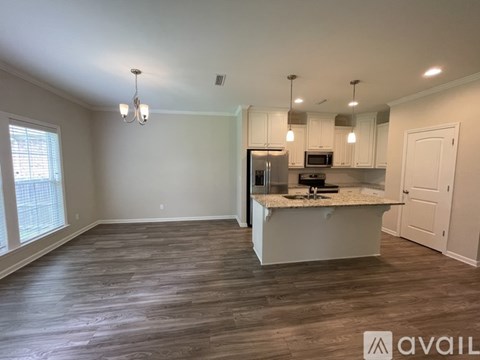 A kitchen with a marble countertop and wooden flooring.