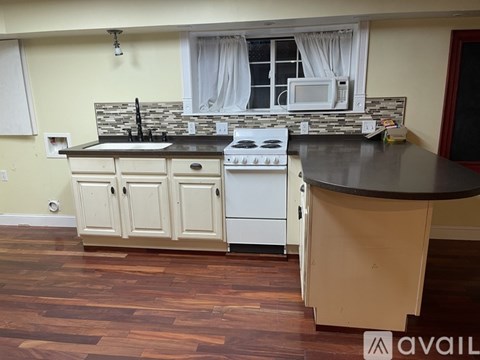 A kitchen with a white stove and a black countertop.