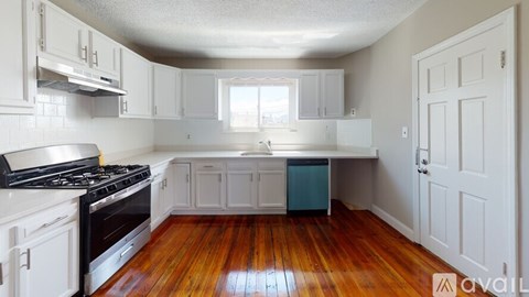 A kitchen with white cabinets and a black stove top.