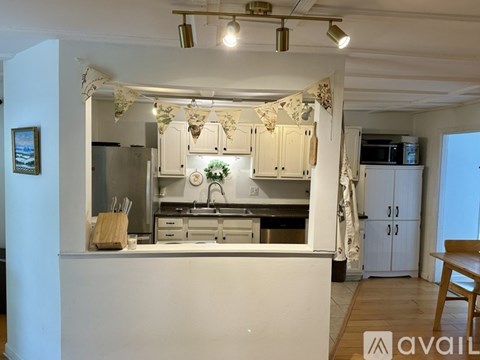 A kitchen with white cabinets and a wooden table.