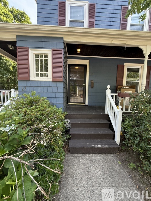A blue house with a white fence and a white porch.
