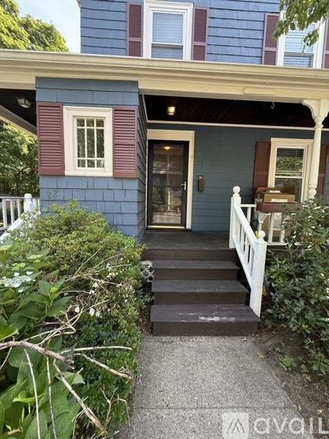 A blue house with a white fence and a white porch.