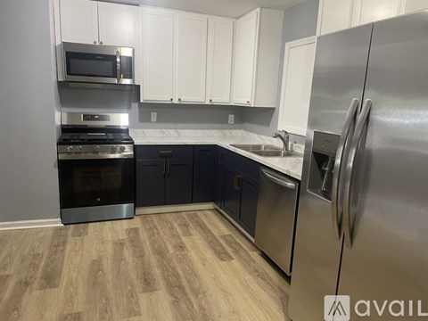 A kitchen with a stainless steel refrigerator, microwave, oven, and cabinets.