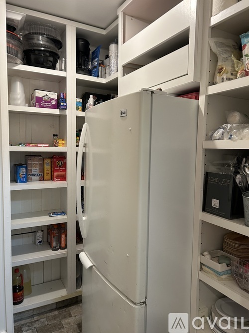 A white refrigerator with its door open is in a kitchen.
