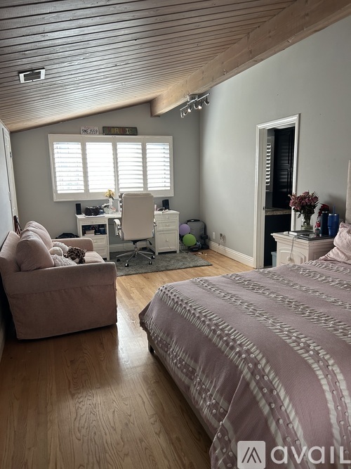 A bedroom with a large bed and a couch.