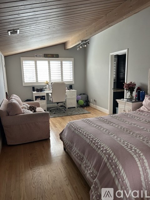 A bedroom with a large bed and a couch.