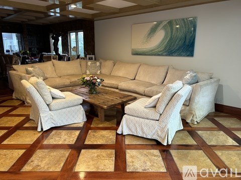 A living room with a large beige sofa and matching armchairs.