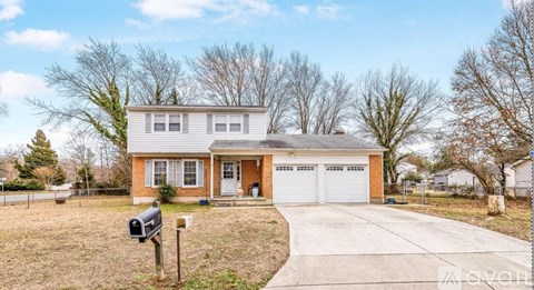 A two-story house with a garage and a driveway.