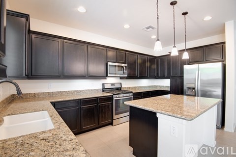 A modern kitchen with dark wood cabinets and a granite countertop.