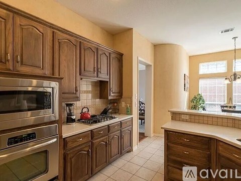 A kitchen with wooden cabinets and a stainless steel oven.