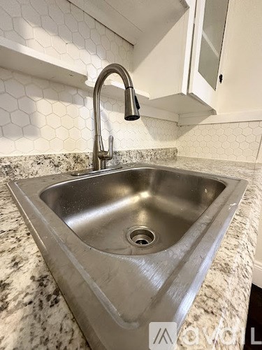 A modern kitchen sink with a chrome faucet.