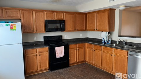 A kitchen with wooden cabinets and a black oven.