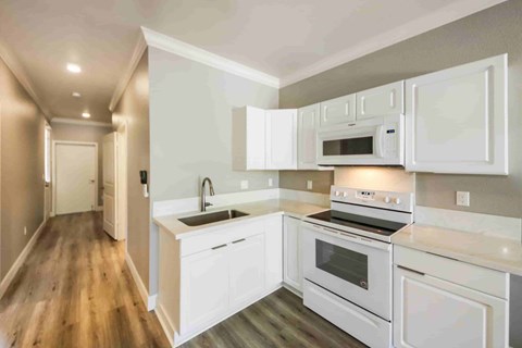 A modern kitchen with white appliances and cabinets.
