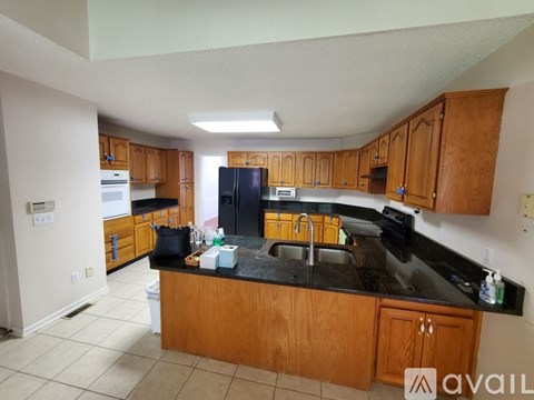 A kitchen with wooden cabinets and black countertops.