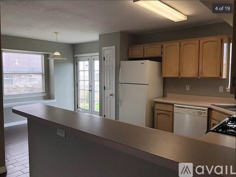 A kitchen with a white refrigerator and wooden cabinets.
